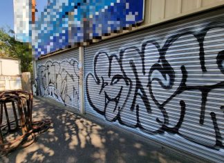 霧峰區福新路一處廢棄鐵工廠整片鐵捲門遭人塗鴉，住在對面的何姓老闆起床後超級傻眼，向霧峰分局報案。（圖/霧峰警分局）
