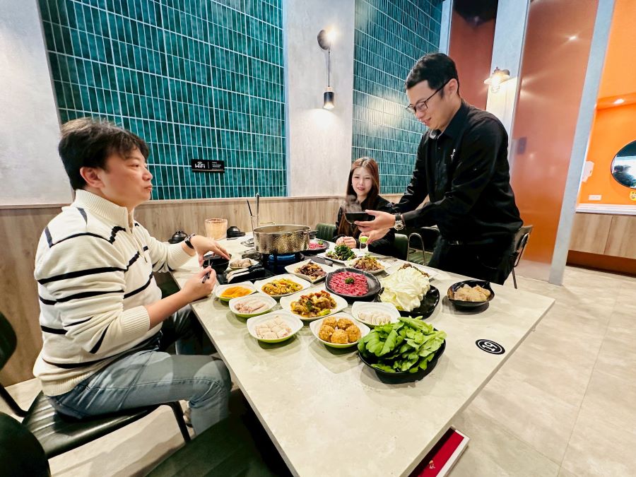 台中「牛境溫體牛涮涮鍋」老闆林育文親自示範溫體牛火鍋吃法。(圖/記者賴淑禎攝)